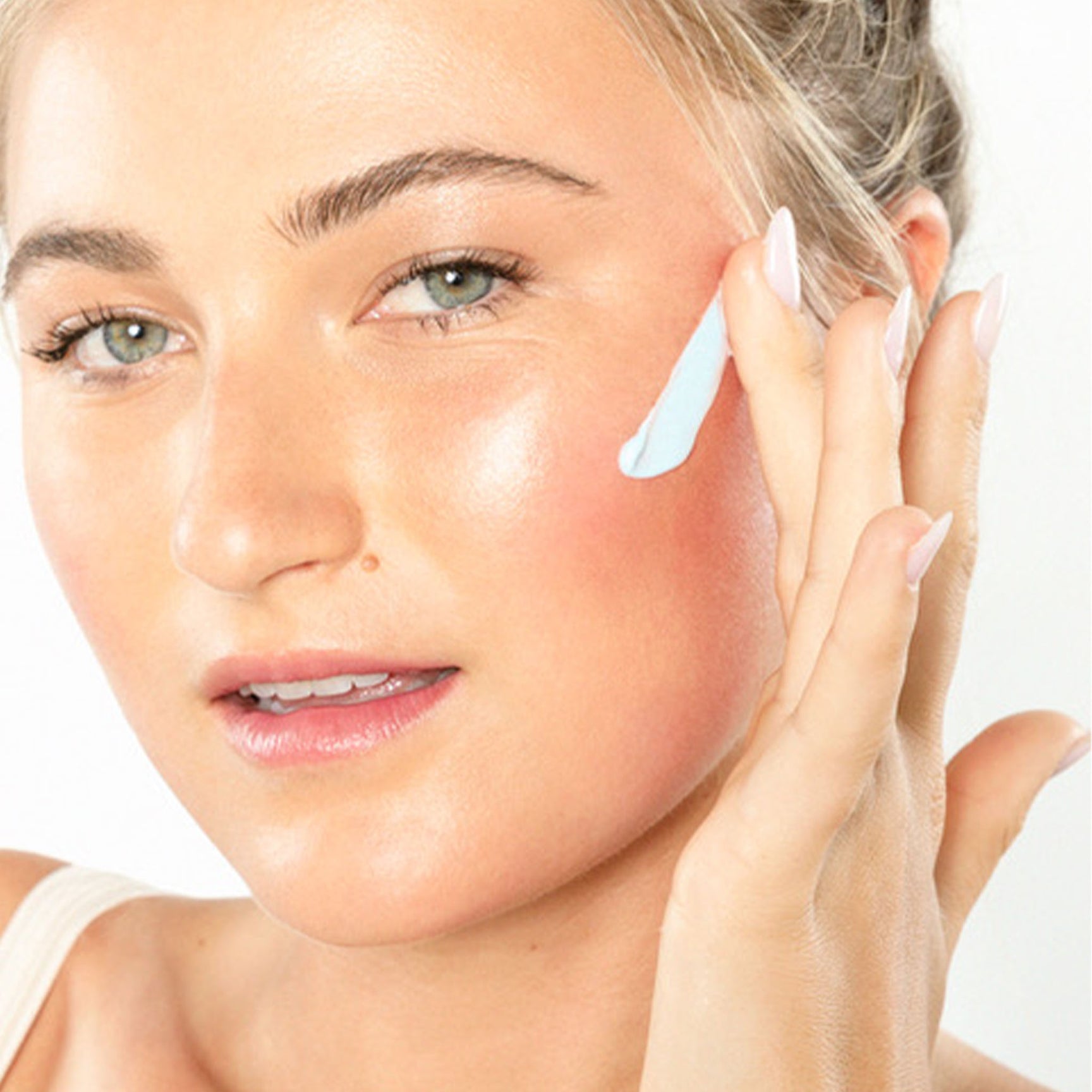relaxed woman applying face cream during evening skincare ritual